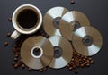 Coffee and Old Technology A Cup of Dark Roast Coffee Beside a Pile of CDs and Coffee Beans Royalty Free Stock Photo