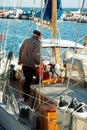 Companions getting ready for another journey. An elderly man and his dog standing in a cluttered boat. Royalty Free Stock Photo