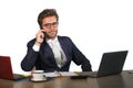 Company corporate isolated portrait of young handsome and attractive businessman working at office desk talking on mobile phone co Royalty Free Stock Photo