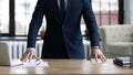 Company executive, CEO, owner in formal suit standing at desk