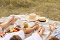 The company of female friends relaxing on summer picnic. Summer rural style picnic concept