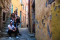 Company frends of young people sitting on a narrow street