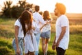 Company of friends chatting in the open air on a sunny day. In the background a young man embraces a girl. Royalty Free Stock Photo