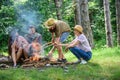 Company friends or family making bonfire in forest nature background. Company youth camping forest prepare bonfire for