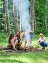 Company friends picnic or barbecue roasting food near bonfire. Best friends spend leisure weekend hike barbecue forest Royalty Free Stock Photo