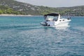 The company of friends on a small motor yacht sails along the coast near a small Mediterranean town. Rest on the water in the Royalty Free Stock Photo