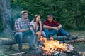 Company friends spend great time picnic or barbecue near bonfire. Picnic friends. Friends roasting hotdogs on sticks at Royalty Free Stock Photo