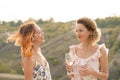 The company of gorgeous female friends having fun, drink wine, and enjoy hills landscape picnic Royalty Free Stock Photo