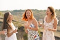 The company of gorgeous female friends having fun, drink wine, and enjoy hills landscape picnic Royalty Free Stock Photo