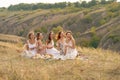 The company of gorgeous female friends having fun, drink wine, and enjoy hills landscape picnic