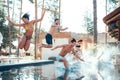 Company of happy young people jumping in pools forming splashes. Swimming pool party concept. Royalty Free Stock Photo