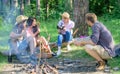 Company having hike picnic nature background. Picnic with friends in forest near bonfire. Hikers relaxing during snack Royalty Free Stock Photo