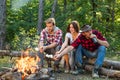 Company having hike picnic nature background. Weekend. Happy young people camping in woods. Hikers sharing impression of Royalty Free Stock Photo