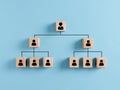 Company hierarchical organizational chart of wooden cubes on blue background. Human resources management and business concept Royalty Free Stock Photo