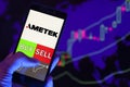 Company logo AMETEK Inc. on smartphone screen, hand of trader holding mobile phone showing BUY or SELL on background of stock char Royalty Free Stock Photo