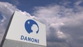 Logo of DANONE on a stand against cloudy sky, editorial 3D rendering