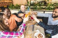 A company of multicultural young people in a cafe eating pizza, drinking cocktails, having fun