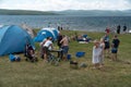 Company of people relax in a tent camp on the shore of a Large lake in the summer season
