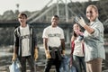 Company of team leader and three young volunteers cleaning up the beach Royalty Free Stock Photo