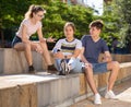 Company of teenagers with smartphones are communicating on walk Royalty Free Stock Photo