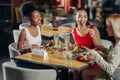 Company of three best friends feeling rested while sitting in restaurant Royalty Free Stock Photo