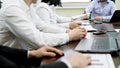 Company workers sitting at table at business meeting, listening to chief speech