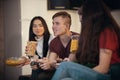 Company of young friends spending time together playing games and eating chips and popcorn Royalty Free Stock Photo