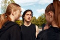 A company of young girls and boys is going to play basketball on the city playground. Royalty Free Stock Photo