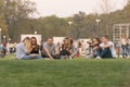 The company of young people sitting on the green lawn at the opening of a new modern Park in the city in the autumn time of year.