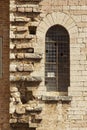 Ancient medieval window contrasted with a modern wall.