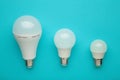 Comparison of different light bulbs on blue background Royalty Free Stock Photo