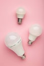 Comparison of different light bulbs on pink background. Vertical photo Royalty Free Stock Photo