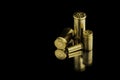 Comparison of sizes of different used bullet shells on a black background with reflection from a tin table top. View of