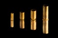 Comparison of sizes of different used bullet shells on a black isolated background with reflection from a tin table top. View of