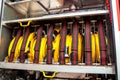 Compartment of rolled up fire hoses on a fire engine. Rescue fire truck equipment.