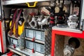 Compartment of rolled up fire hoses on a fire engine. Rescue fire truck equipment. A silver fire hydrant with red valves and other