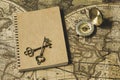 Compass, antique keys and notebook on blur vintage world map, journey concept, copy space Royalty Free Stock Photo