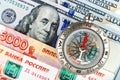 Compass with arrow pointing up on the background of Russian and American banknotes Royalty Free Stock Photo