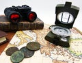 Compass, binoculars and old book on vintage map, white background Royalty Free Stock Photo