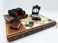 Compass, binoculars and old book on vintage map, white background Royalty Free Stock Photo