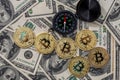 Compass with bitcoin over dollar bills