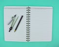 Compass and a black pen on top of a open note paper diary isolated on a white background Royalty Free Stock Photo