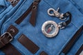 Compass and blue travel backpack, tourist items close-up, magnetic compass with metal clasp