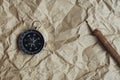 Compass, burnt brown paper and wooden pencil on crumples paper background, vintage tone, journey planning concept, blank space, Royalty Free Stock Photo