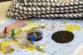 a compass a climbing rope and an old copper coin on the geographical map the buttons mark the places the concept of Royalty Free Stock Photo