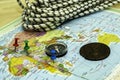 a compass a climbing rope and an old copper coin on the geographical map the buttons mark the places the concept of Royalty Free Stock Photo