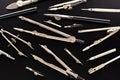 Set of old different compasses. Retro metal compasses and drafting tools on a black background. Drawing pen. Royalty Free Stock Photo