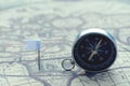 Compass and flag pins on blur vintage world map, journey concept