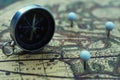 Compass and flag pins on blur vintage world map, journey concept