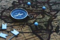 Compass and flag pins on blur vintage world map, journey concept